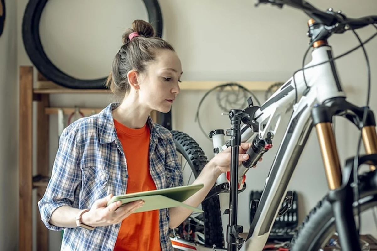Kobieta wykonuje konserwację roweru górskiego