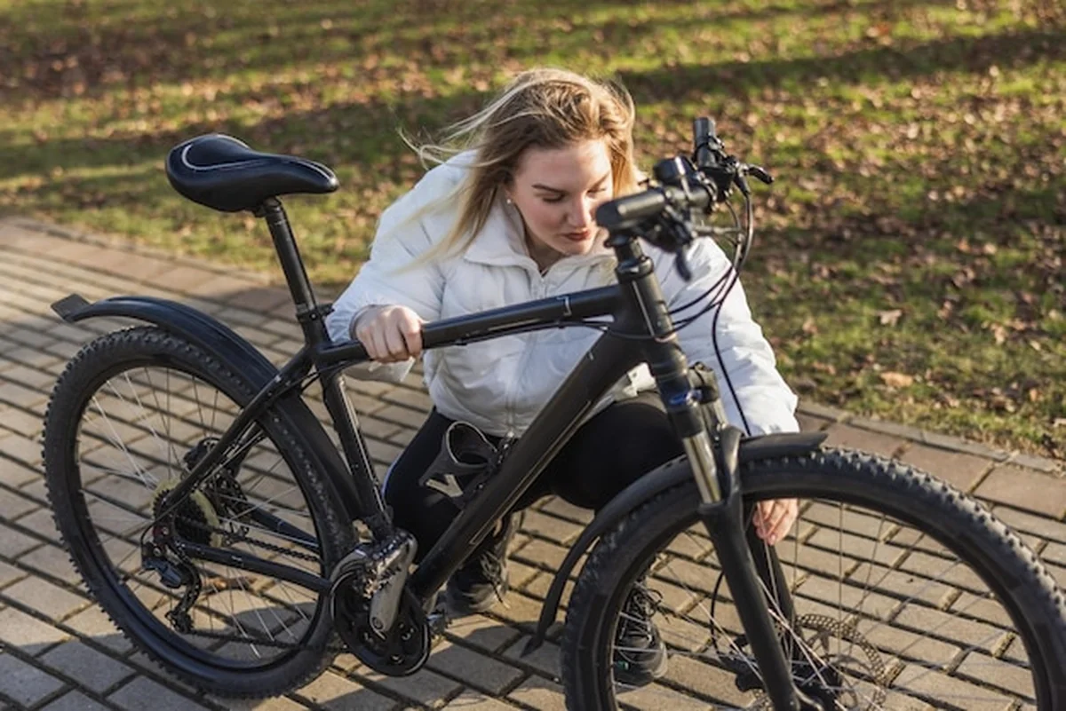 Kobieta sprawdza rower górski w parku jesienią