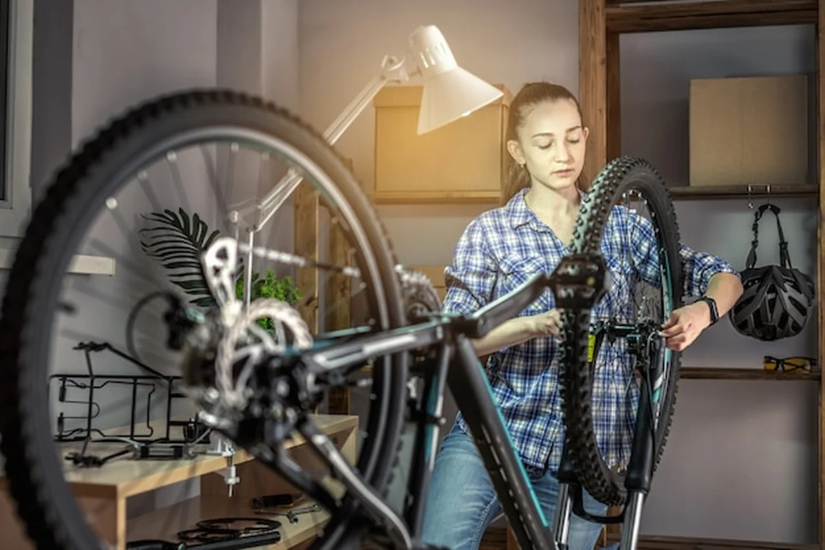 Kobieta konserwuje rower górski przed sezonem
