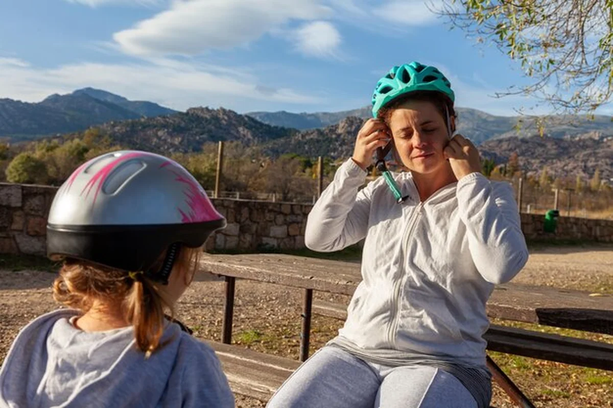 Matka i córka dopasowują kaski przed przejażdżką rowerową