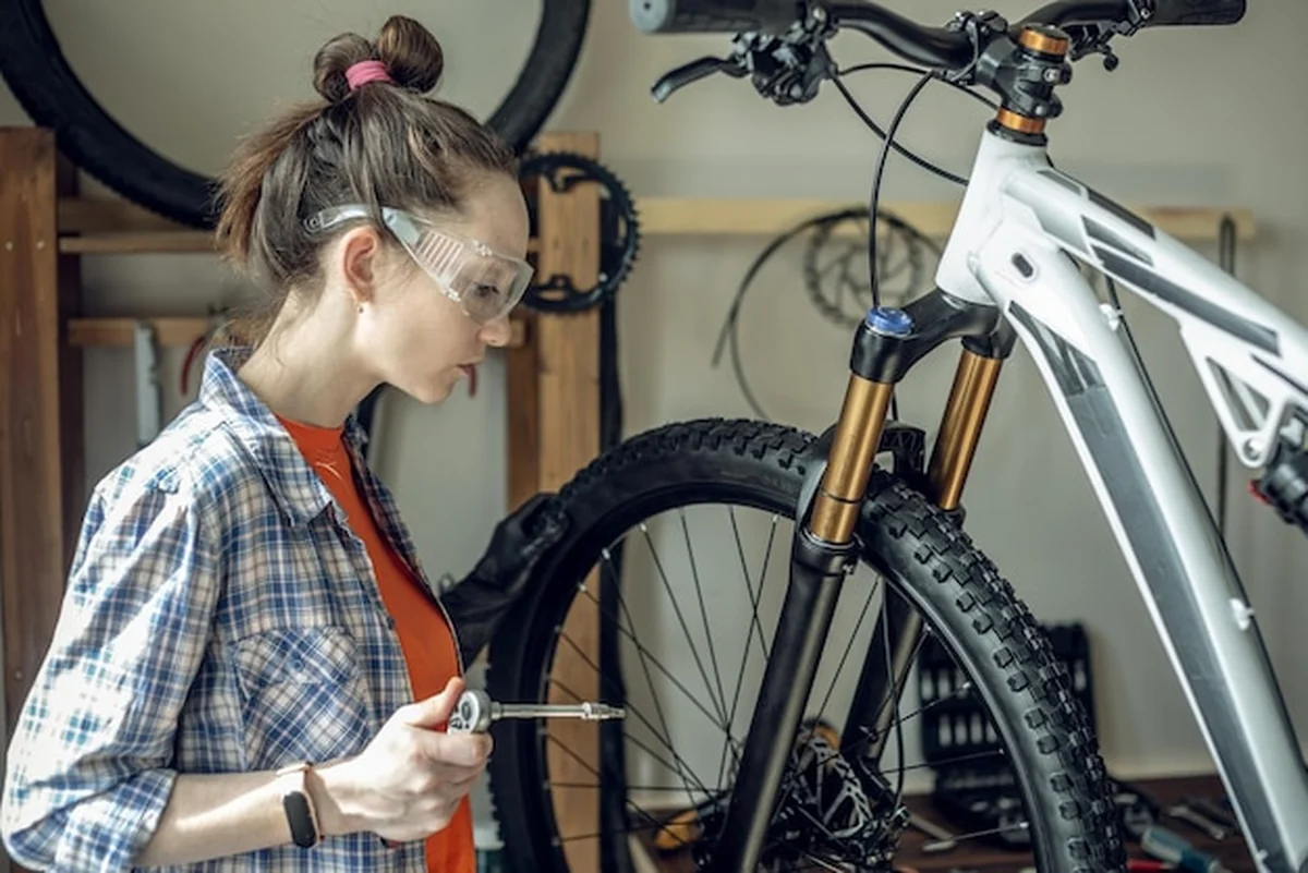 Kobieta wykonuje konserwację roweru górskiego
