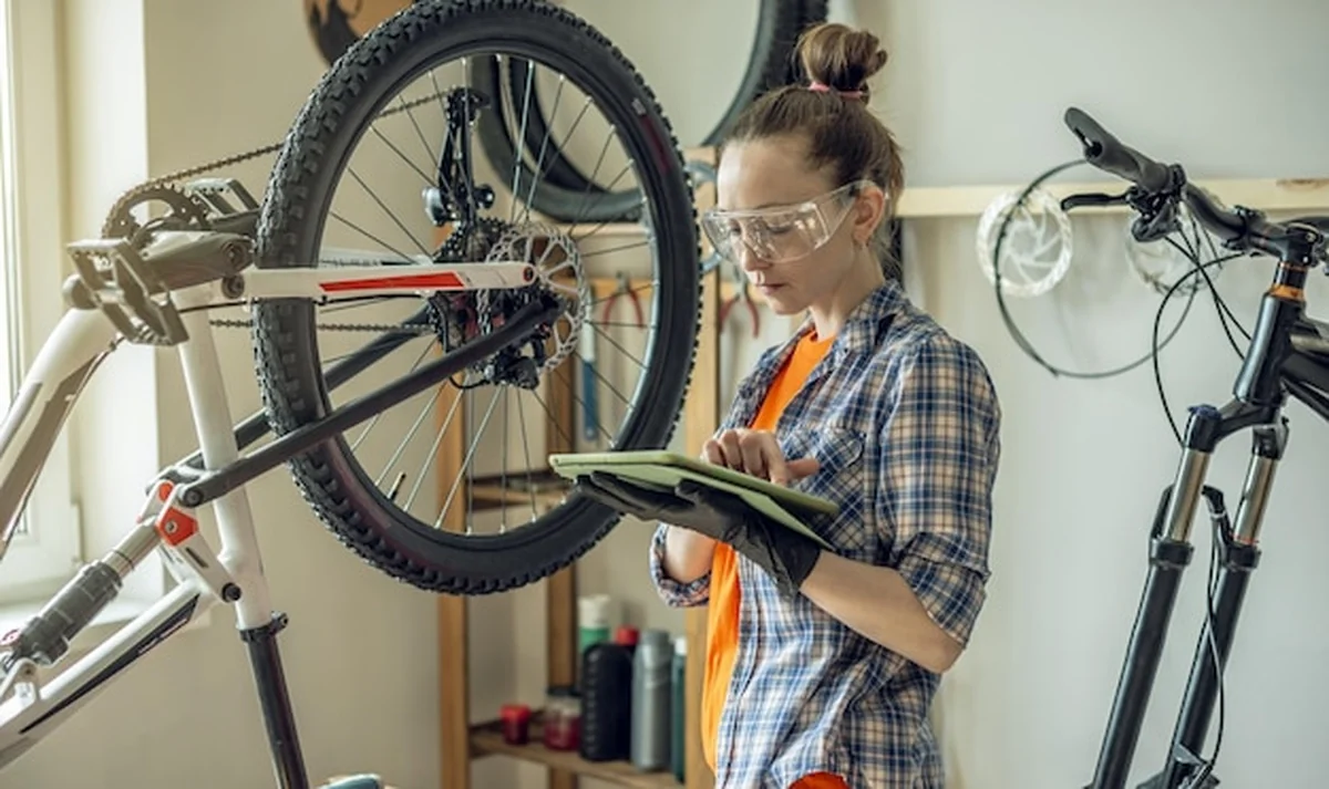 Kobieta naprawia rower w warsztacie. Przygotowanie do sezonu, naprawa i konserwacja